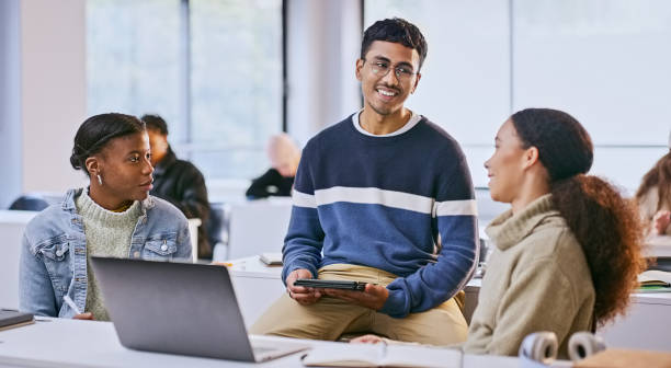 istock Students, group and discussion in college classroom with learning, research and brainstorming for test. University, diversity and teamwork with laptop, tablet and books for education or exam study 1969855109
