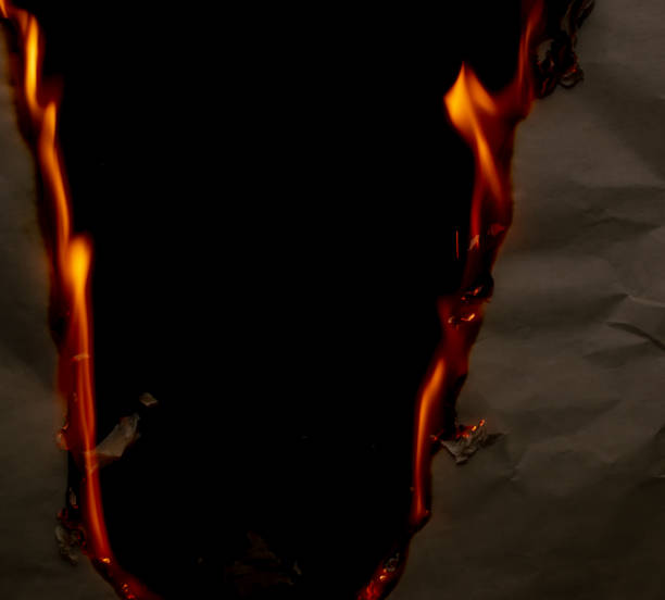 istock burning paper, glowing edge of paper 1969865528