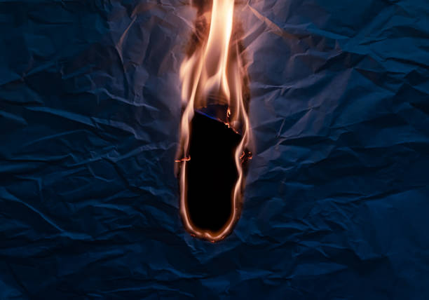 Firefighter bravely faces intense flames, standing firm in heavy protective gear as water spray surrounds.Moment captures courage, danger, and the high pressure of emergency fire response operations.