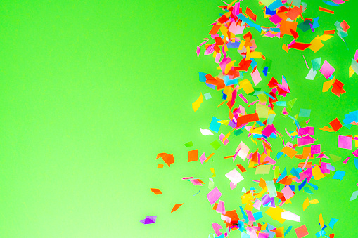 Falling multi colored confetti on green background. High resolution 42Mp studio digital capture taken with Sony A7rII and Sony FE 90mm f2.8 macro G OSS lens