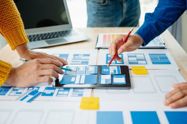 istock View of UI developer team brainstorming on their project with laptop, smartphone and digital tablet. Creative digital development agency. 1969874181