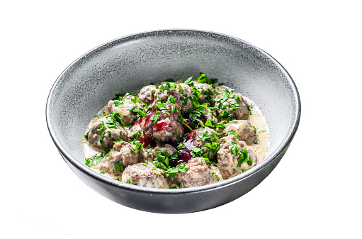 Ground beef meatballs with cream sauce on a plate.  Isolated on white background. Top view