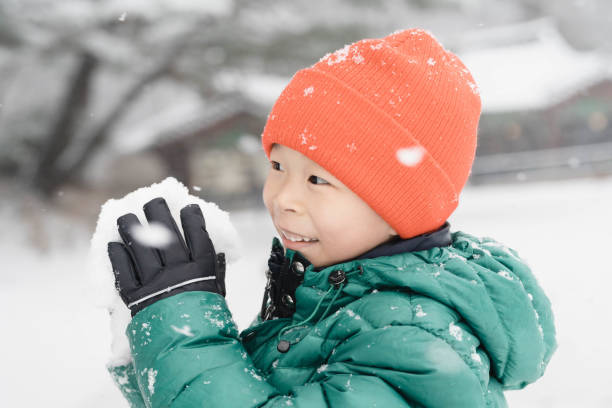Brothers Sliding in the Snow Outdoors in Winter. They are having a lot of fun.
