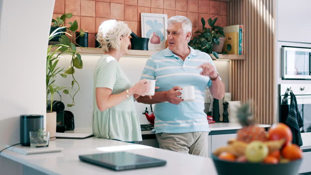Senior couple, drinking coffee and loving communication in kitchen, bonding and relaxing together. Elderly people, tea and beverage in morning routine, conversation and happy in retirement at home