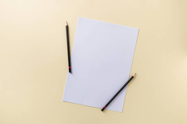 istock Blank white paper and black pencil on yellow background 1969971728