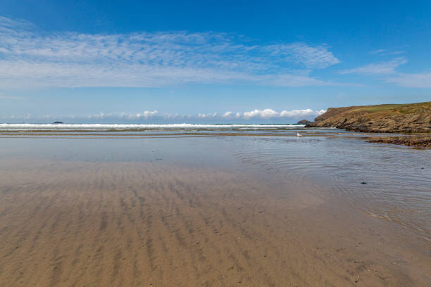 Looking out over the sandy beach at Polzeath in Cornwall, with a blue sky overhead