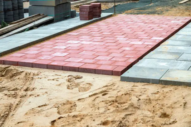 Red concrete blocks for cycle path in the sand bed