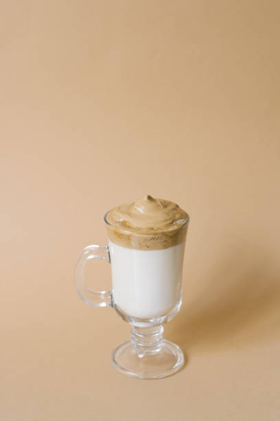 istock Beautiful dalgon drink coffee with foam in a transparent mug on a beige background 1970003492