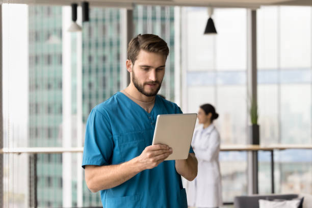 istock Serious handsome doctor man using medical online application on tablet 1970014299