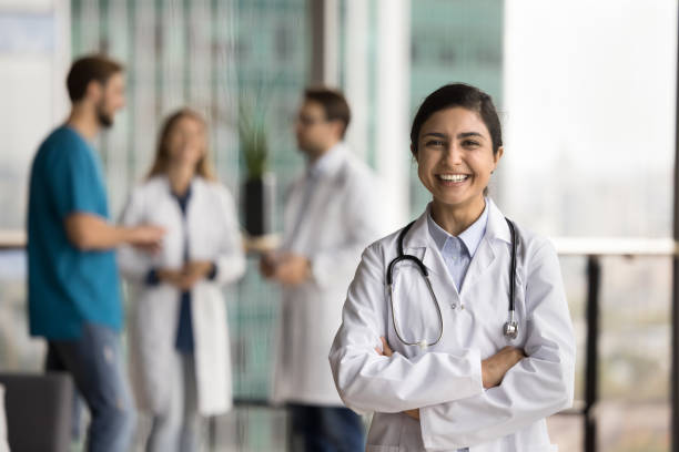 Cheerful beautiful Indian doctor woman in uniform enjoying medical occupation stock photo