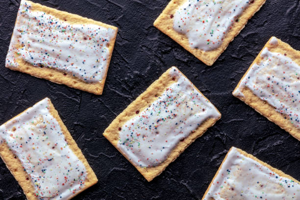 istock Pop tarts layout. Poptart toaster pastry with icing on a black slate background 1970016992