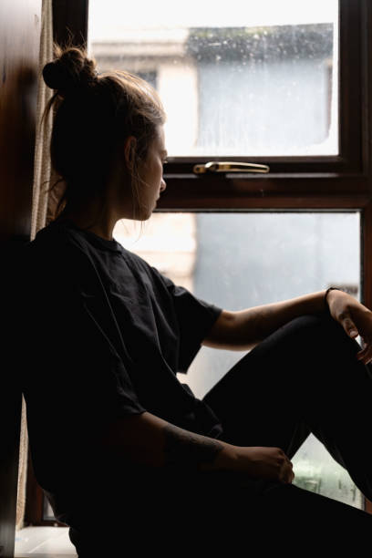 istock woman sitting at the window 1970024911