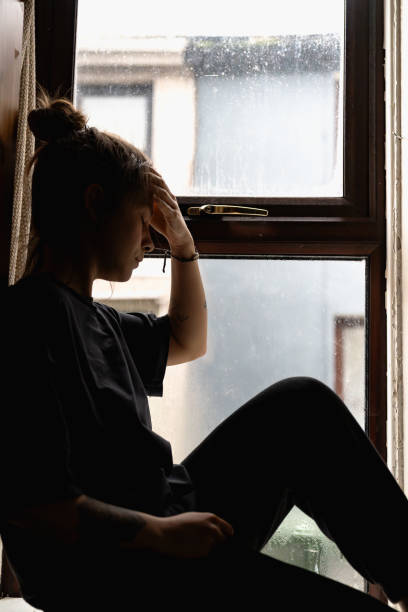 istock woman sitting at the window 1970024912