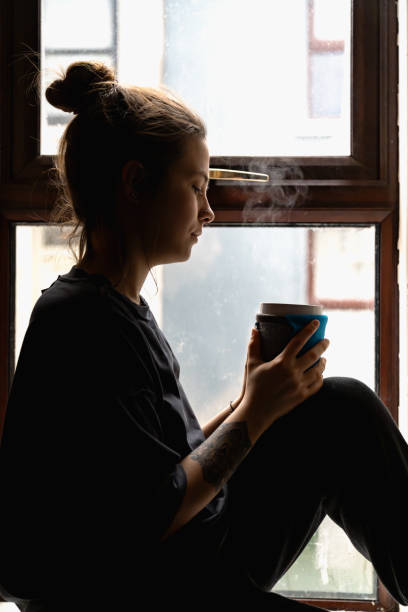 istock woman sitting at the window 1970024924
