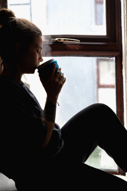 istock woman sitting at the window 1970025451