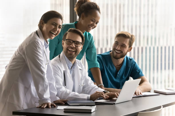 istock Group of cheerful diverse doctors laughing at laptop 1970028109