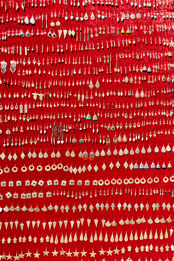 Large group of traditional Moroccan earrings on red background in Chefchaouen, Morocco, North Africa.