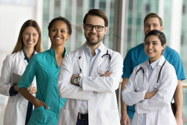 istock Happy chief doctor man with stethoscope posing for group port 1970054717