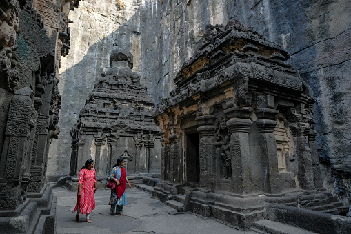 Ellora, India - January 22, 2024: Two women visiting the Kailasa Temple in the Ellora Caves complex in the Aurangabad District of Maharashtra, India.