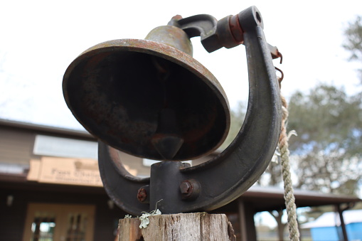 A closeup shot of a vintage bell attached to rope