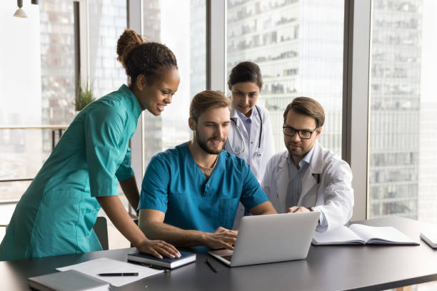 istock Diverse team of positive successful medical professionals using laptop 1970096027