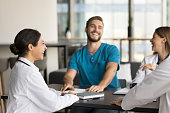 Cheerful young Indian doctor woman laughing at professional meeting