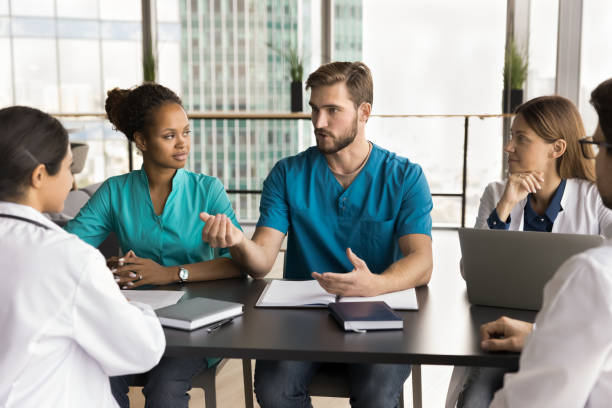istock Serious handsome doctor man in uniform speaking to multiethnic colleagues 1970123077