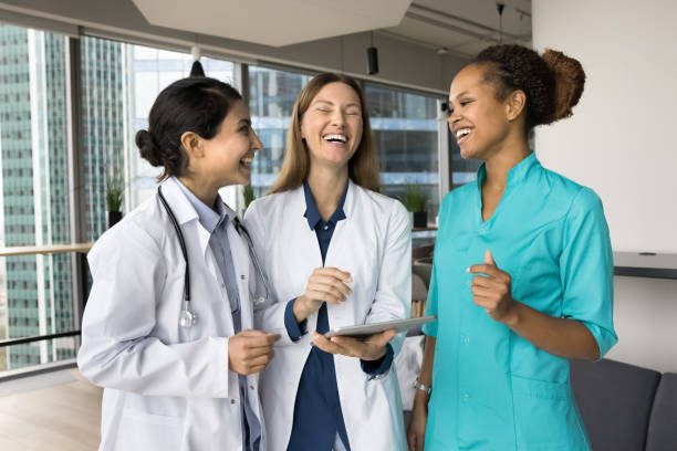 istock Cheerful colleagues in uniform coats talking in hospital office hall 1970124614
