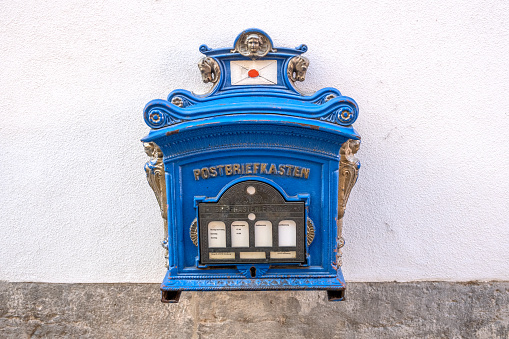 Old blue mailbox on a white wall in the city of Wurzburg, Germany