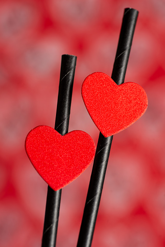 Red heart shapes on black sticks over red background