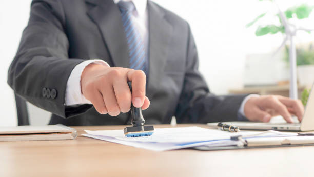 Image of a businessman who approves or allows. On Text Approved Document At Desk, Contract Form Paper.