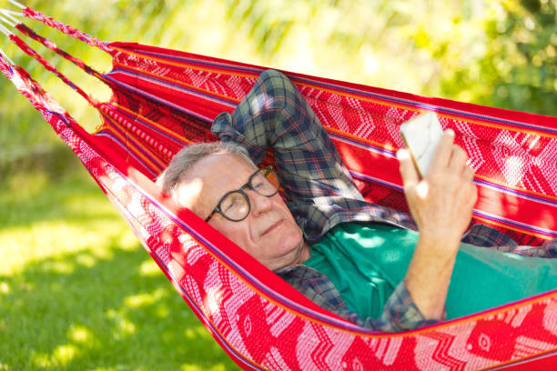 istock Senior man wearing eyeglasses lying on hammock 1970155622