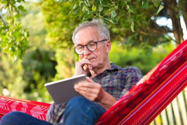 istock Senior man wearing eyeglasses sitting on hammock 1970156648