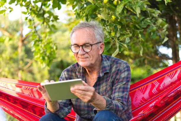 istock Senior man wearing eyeglasses sitting on hammock 1970157164