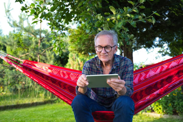 istock Senior man wearing eyeglasses sitting on hammock 1970157688