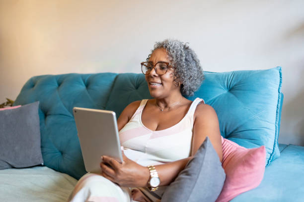 istock Middle-aged black woman using tablet in living room 1970183516