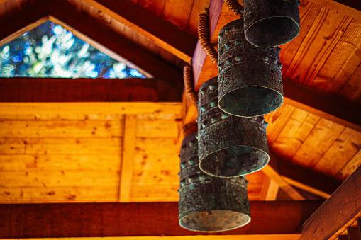 A plethora of weathered metal bells suspended from the ceiling