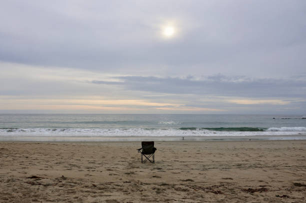 Two empty chairs on a Tulum beach waiting for someone to sit in them.