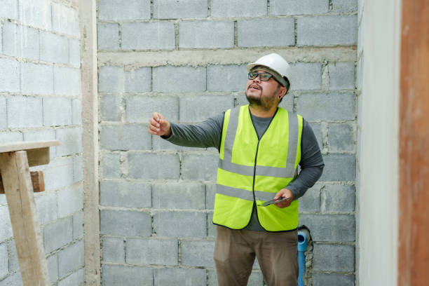 Asian male construction engineer, wearing full clothing, safety helmet, reflective vest, holding laptop in hand, checking work site for completeness, following construction plans. ingeniero de construcción masculino asiático, con ropa completa, casco de seguridad, chaleco reflectante, sosteniendo una computadora portátil en la mano, verificando que el sitio de trabajo esté completo, siguiendo los planos de construcción.