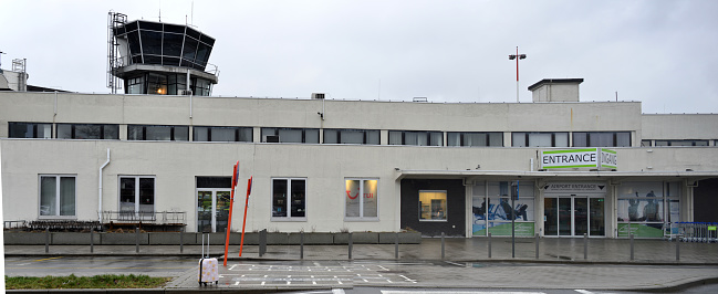 Deurne, Antwerpen, Belgium - January 26, 2024: 2 women in the office seen from outdoors frontal entrance  International airport on a rainy day