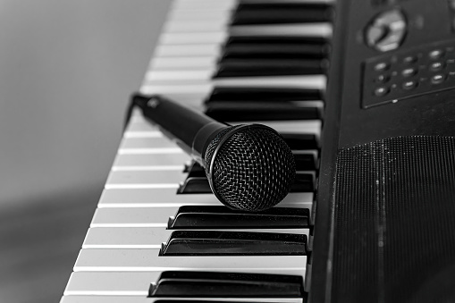 a microphone on a keyboard in black and white