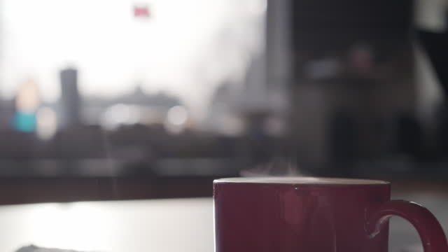 Close up macro video of coffee steaming and being reflected by sun looking very dramatic