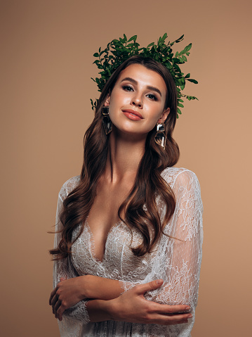 Young beautiful girl with wreath of leaves on the head