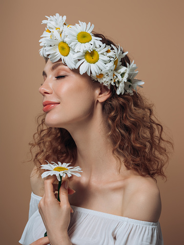 Young beautiful girl with beautiful flowers on her head