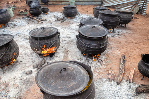 africa outdoors kitchen lot of three legged pots cooking at an event