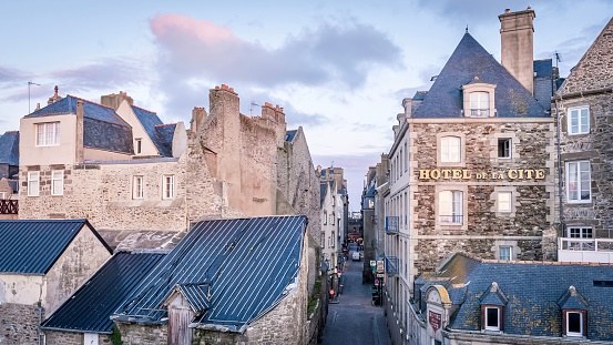 Saint Malo, France – July 13, 2022: A European town street next with pink clouds in the sky, Saint-Malo, France