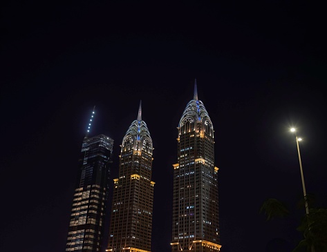 Dubai, United Arab Emirates - 01 19 2024: The business central towers in the Dubai commercial district at night