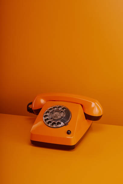 old fashioned vintage telephone. orange retro phone on orange background - obsolete landline phone old 1970s style foto e immagini stock