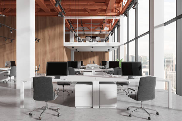 istock Modern coworking interior with desk and pc monitors in row, panoramic window 1970319794