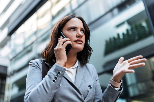 Worried angry businesswoman using phone